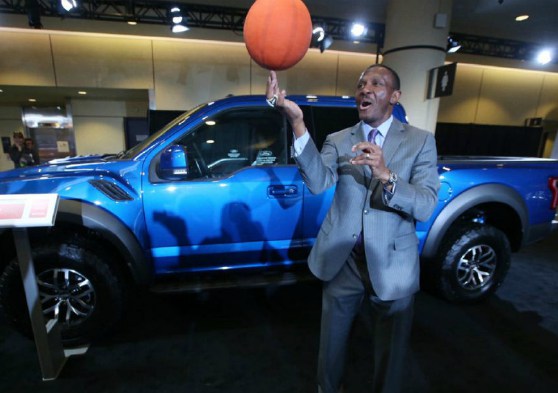 Brenda Casey's husband, Dwane Casey posing with a car