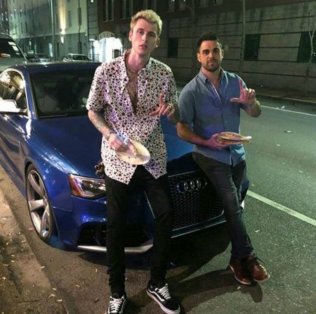 Machine Gun Kelly and his friend posing with a car