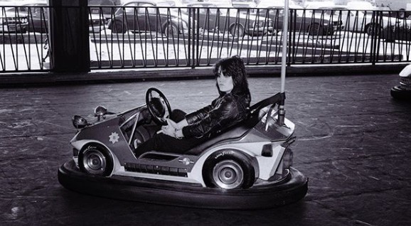 Joan Jett driving playing car in the fun park