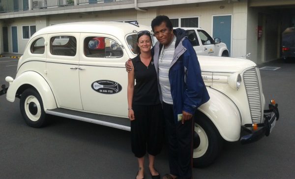 Rozene Cohran's husband posing for photo with his friend with classic car in the background