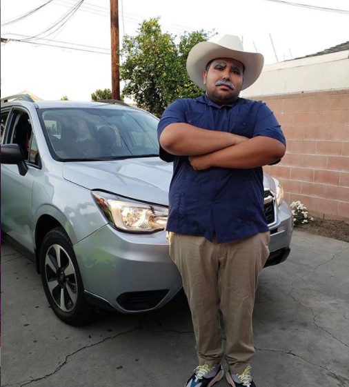 Don Cheto posing for photo with his car in the background