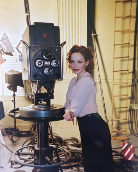 Christina Hendricks posing for a photo with a classical camera