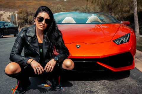Daria Berenato posing for a photo with ferrari car in the background