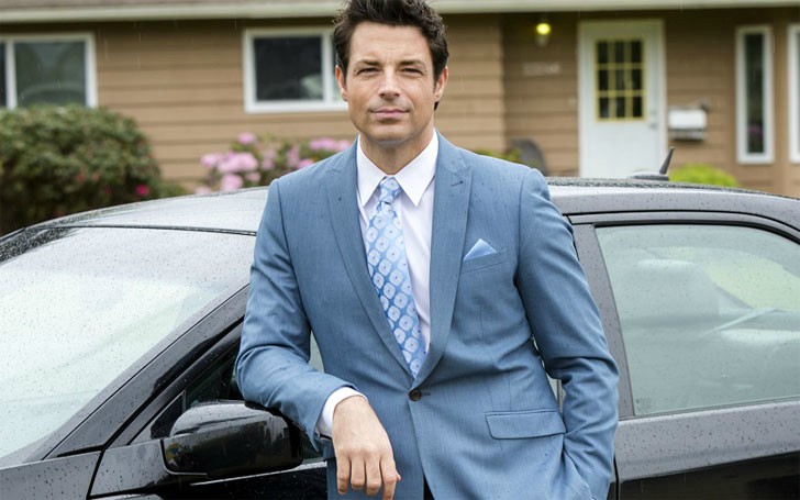  Brennan Elliott posando para una foto con el coche de fondo