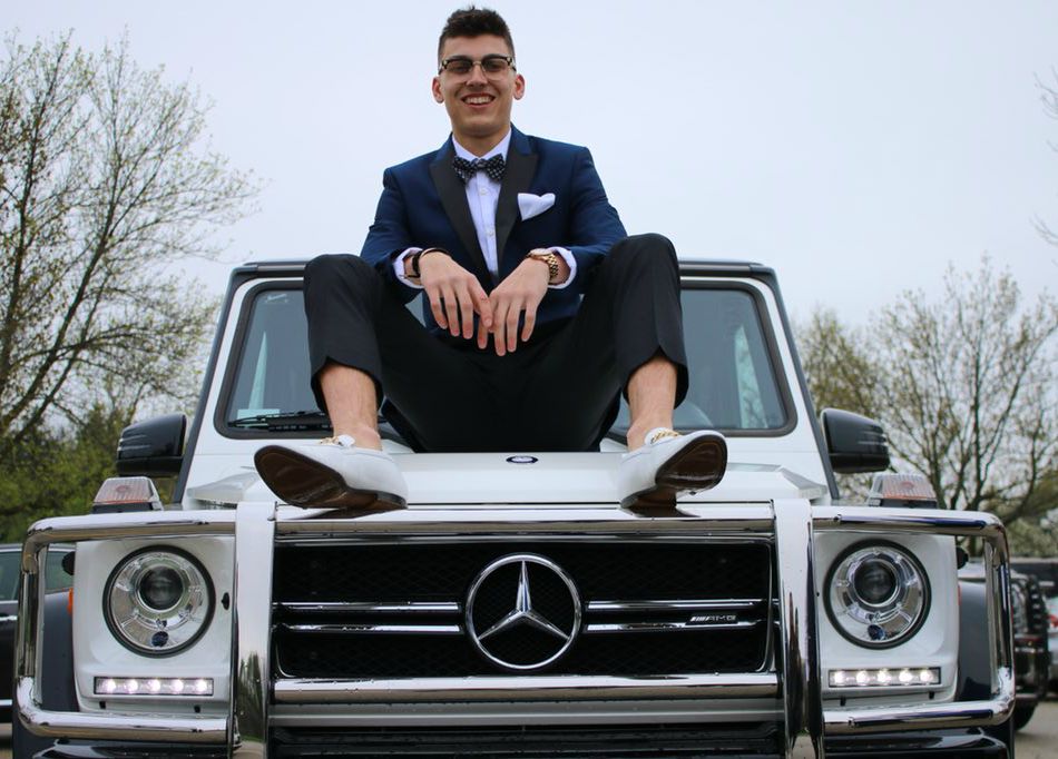 Tyler Herro posing for a photo sitting outside the car