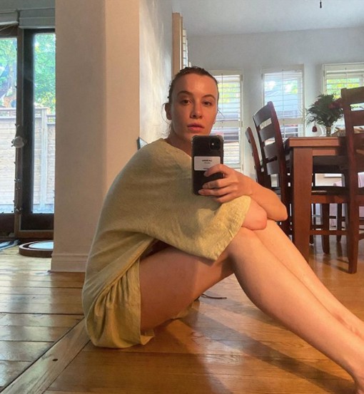 Rebecca-Jo Dunham clicking selfie sitting inside her house