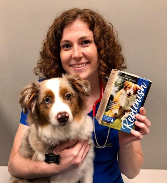 Dr. Lauren Thielen posing for picture with dog and their products