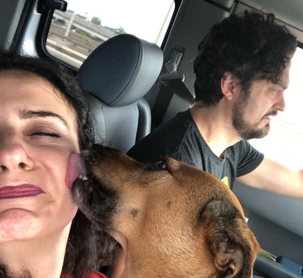 Artemis Pebdani clicking selfie while sitting in car with a dog