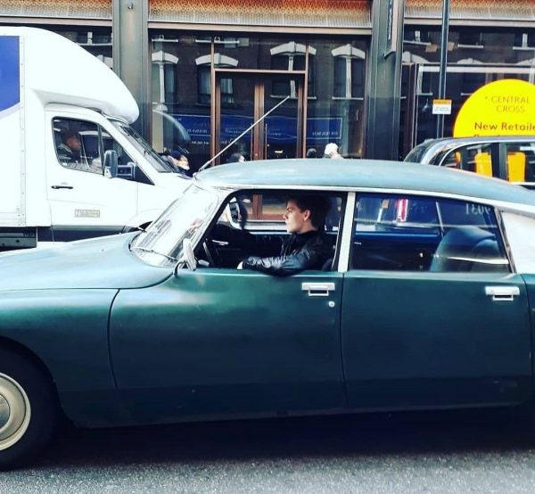 Thomas Brodie-Sangster sitting inside the car