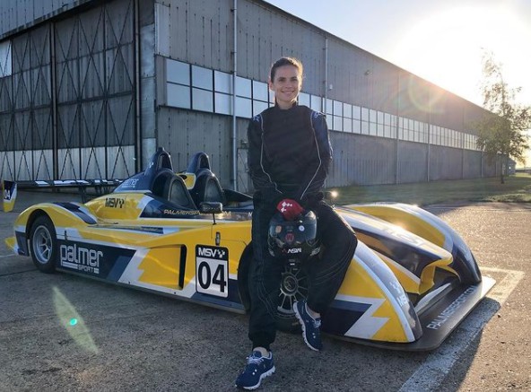 Hayley Atwell posing for photo with a racing car