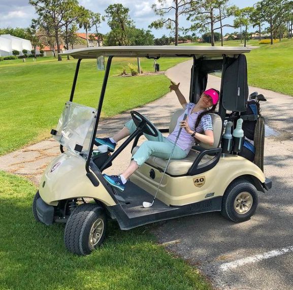 Simply Nailogical posing for picture the golf car