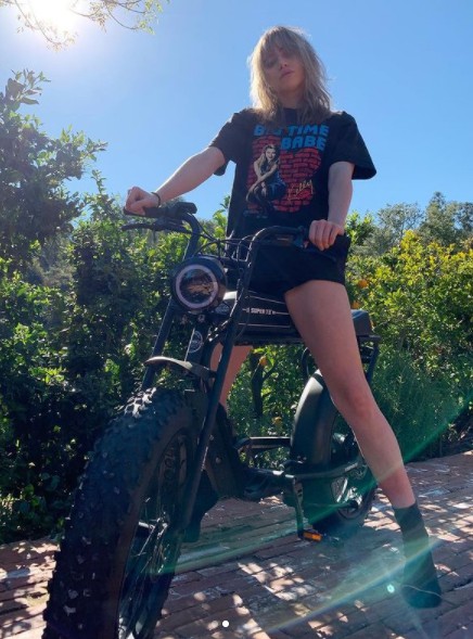 Suki Waterhouse posing for photo with electric bike