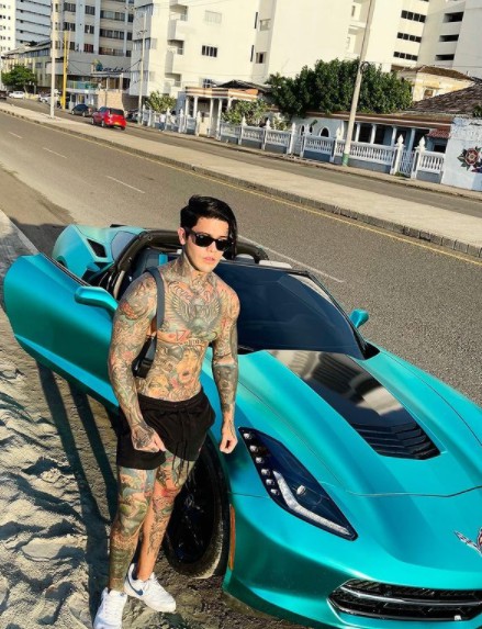 Yeferson Cossio posing for picutre with a classic car