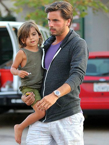 Mason Disick's father Scott carrying him