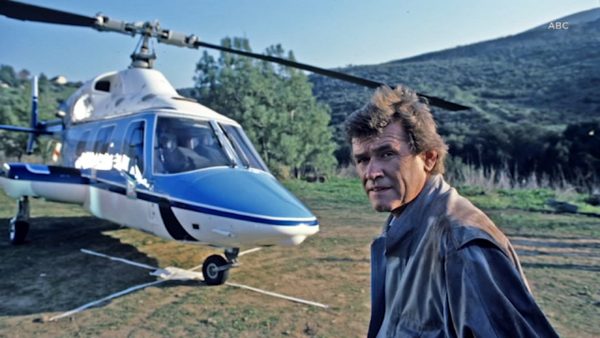 John Reilly posing for photo with helicopter in the background