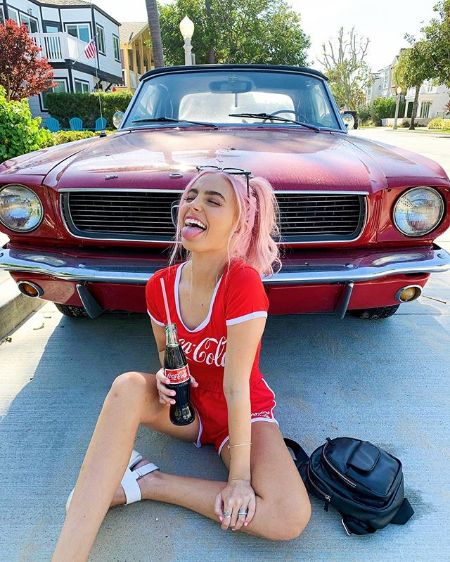 Lexi posing in front of her car