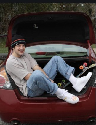 Troy Zarba posing with his car 
