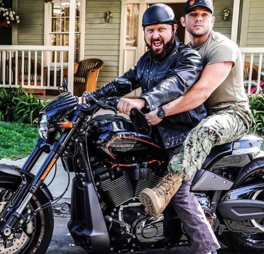 Max Thieriot posing in a bike with his friend