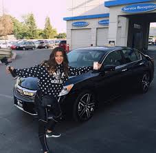 Caption: Tessa Brook posing for the photo with her car
