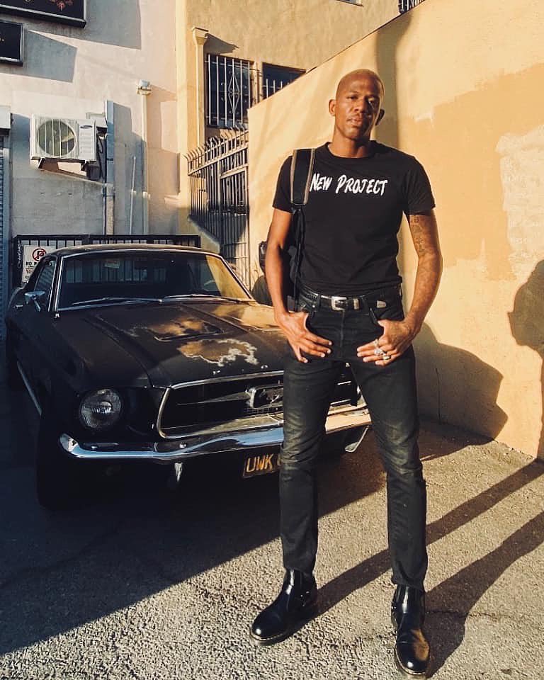 Caption :Marcus Allen posing for the photo with his car