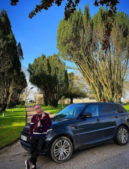  Sean Pertwee posing photo with a car