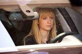 Caption: Beth Riesgraf driving the car