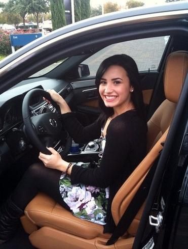 Caption: Demi Lovato posing for the photo inside her car