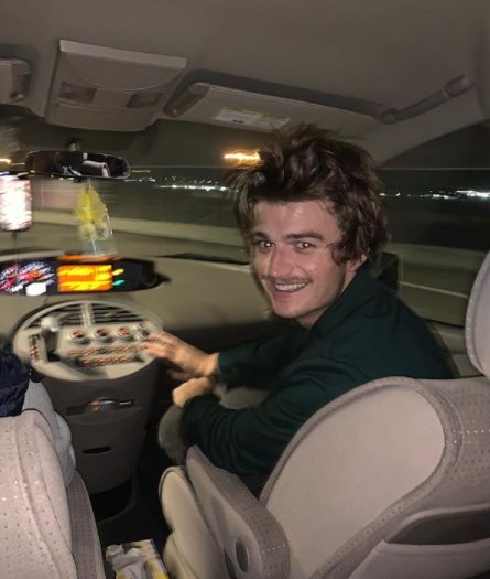 Joe Keery sitting inside the car