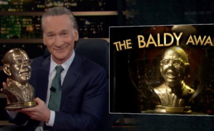 Bill Maher posing for a photo with award