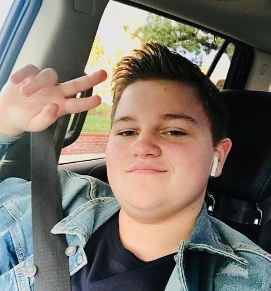 Connor Cain posing inside his car