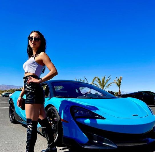 Lizzy Capri posing for a photo with her car