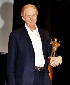 Charles Dance posing for a photo with award
