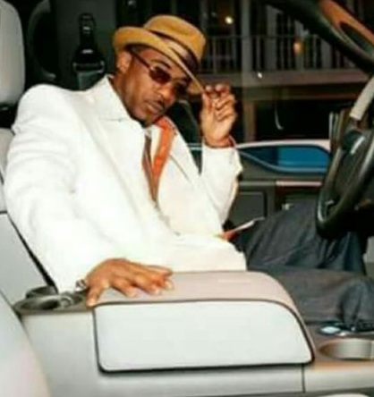 Amber Serrano's husband, Ralph Tresvant posing with his car