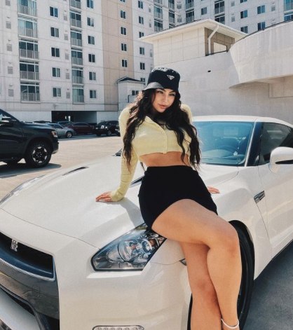 Emily Rinaudo posing with her car