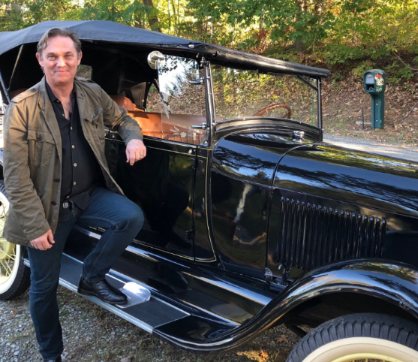 Georgiana Bischoff's husband, Richard Thomas posing with his car