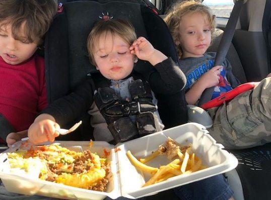 Hank Greenspan and his siblings eating on their car