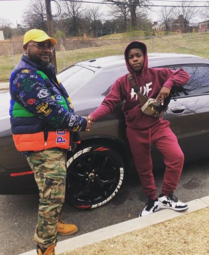 Jalyn Hall and his dad posing with their car