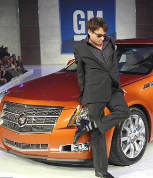 Chris Kattan posing for a photo with his car