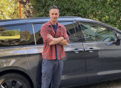 Freddie James Prinze Jr posing for a photo with car 