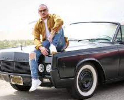 Casper Smart posing for a photo with his car