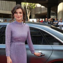 Aisling Bea standing outside the car 