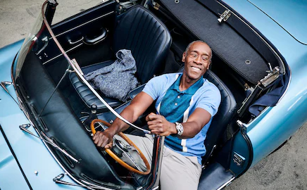 Don Cheadle sitting inside the car