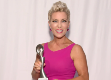 Kelly L. Frey posing for a photo with award