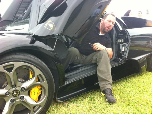 Bert Kreischer posing for a photo with a car
