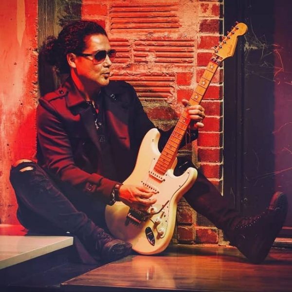 Chris Perez posiert für das Foto mit der Gitarre