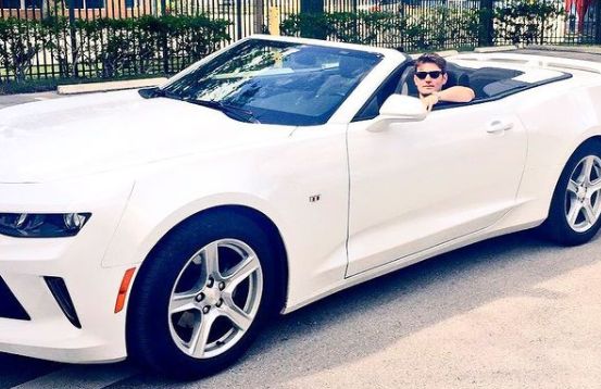 Emmet Cahill posing with his car