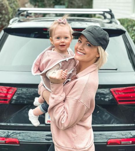 Jenna Cooper and her daughter posing with their car
