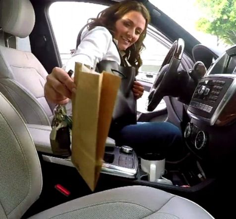 Jenni Pulos posing inside her car