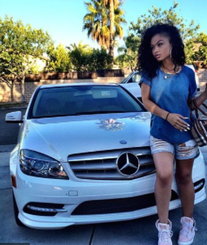 India Love posing for photo with car