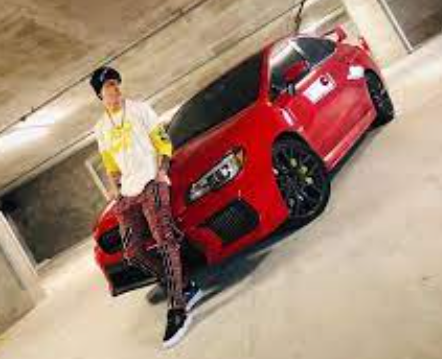Christopher Vélez posing for a photo with car